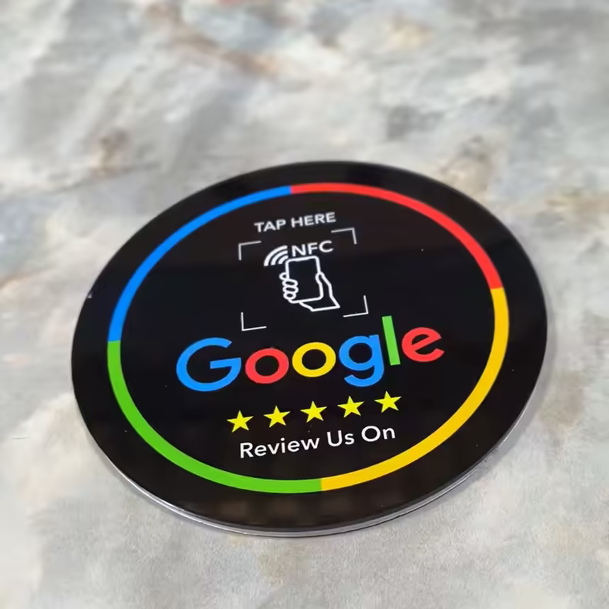 Placa NFC negra de reseñas de Google sobre una encimera de mármol